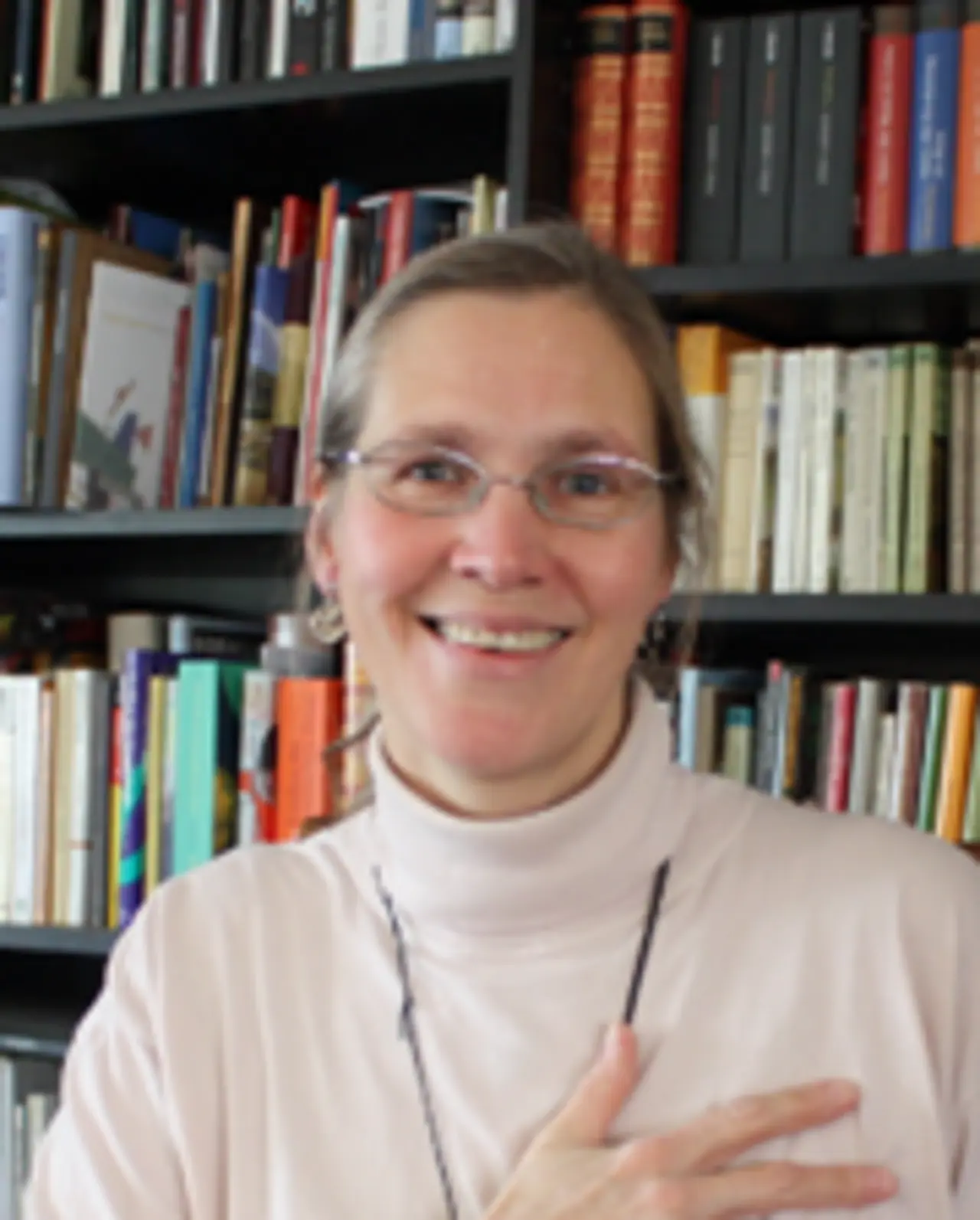 Portraitfoto von Pfarrerin Rostalsky vor einem Bücherregal